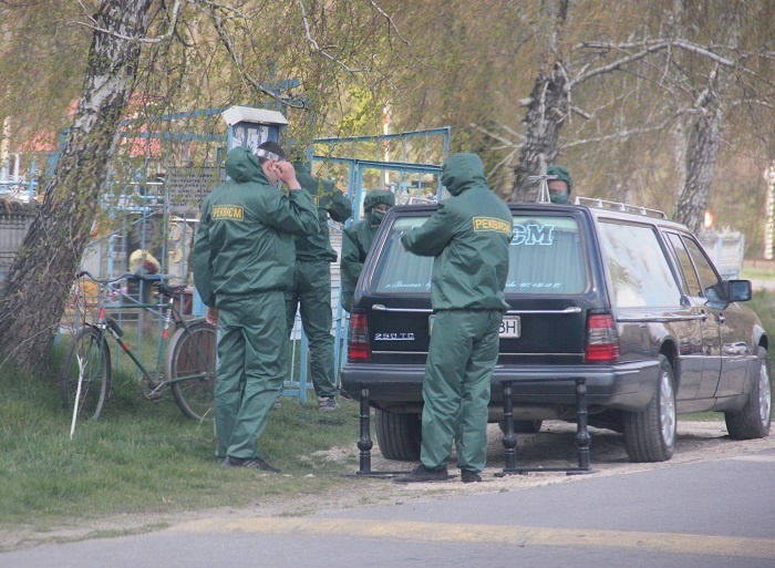 Працівники ритуальної служби знімають захисний одяг