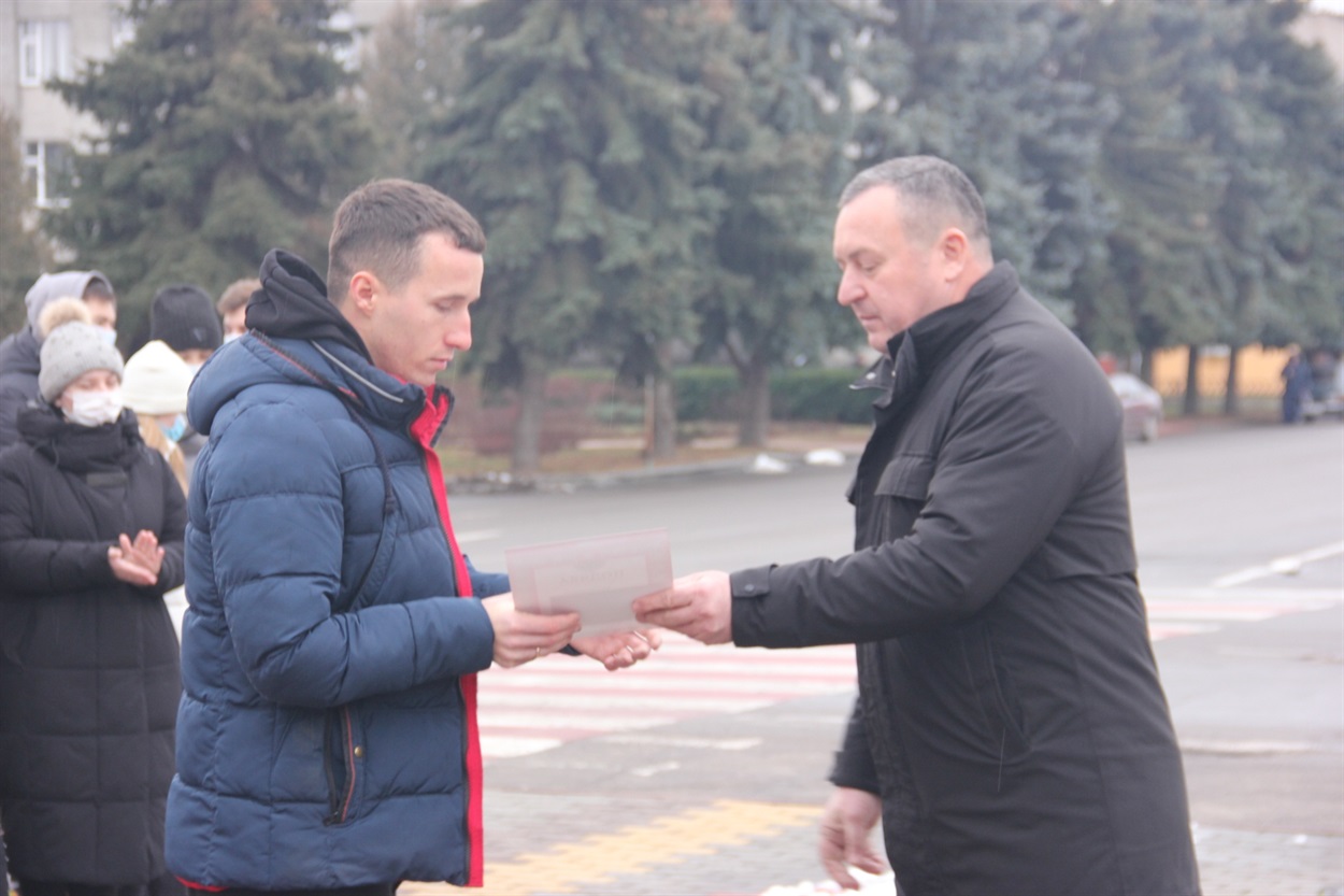 Волонтер Дмитро Васільчіков (ліворуч) отримує відзнаку з рук Миколи Господарця