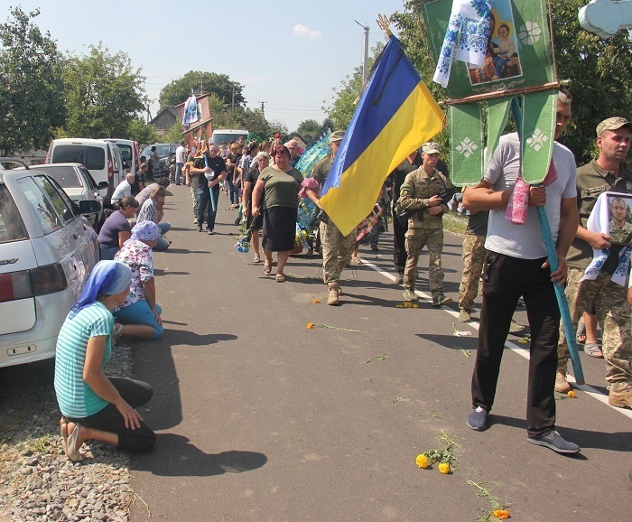 Односельчани на колінах віддають шану воїнові