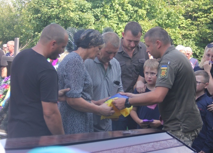 Рідним Олега передають державного прапора України, за яку воїн віддав життя