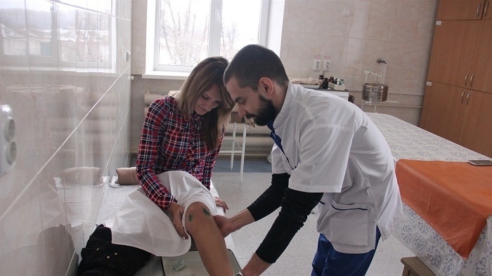 Юрій Кацай оглядає пцієнтку, якій зробили артроскопічну операцію на колінному суглобі