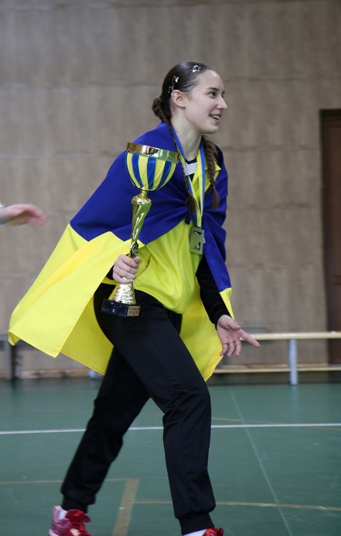 Дарина Корнійчук із кубком за перемогу в чемпіонаті України (2024). Прапор ще без автографів військових